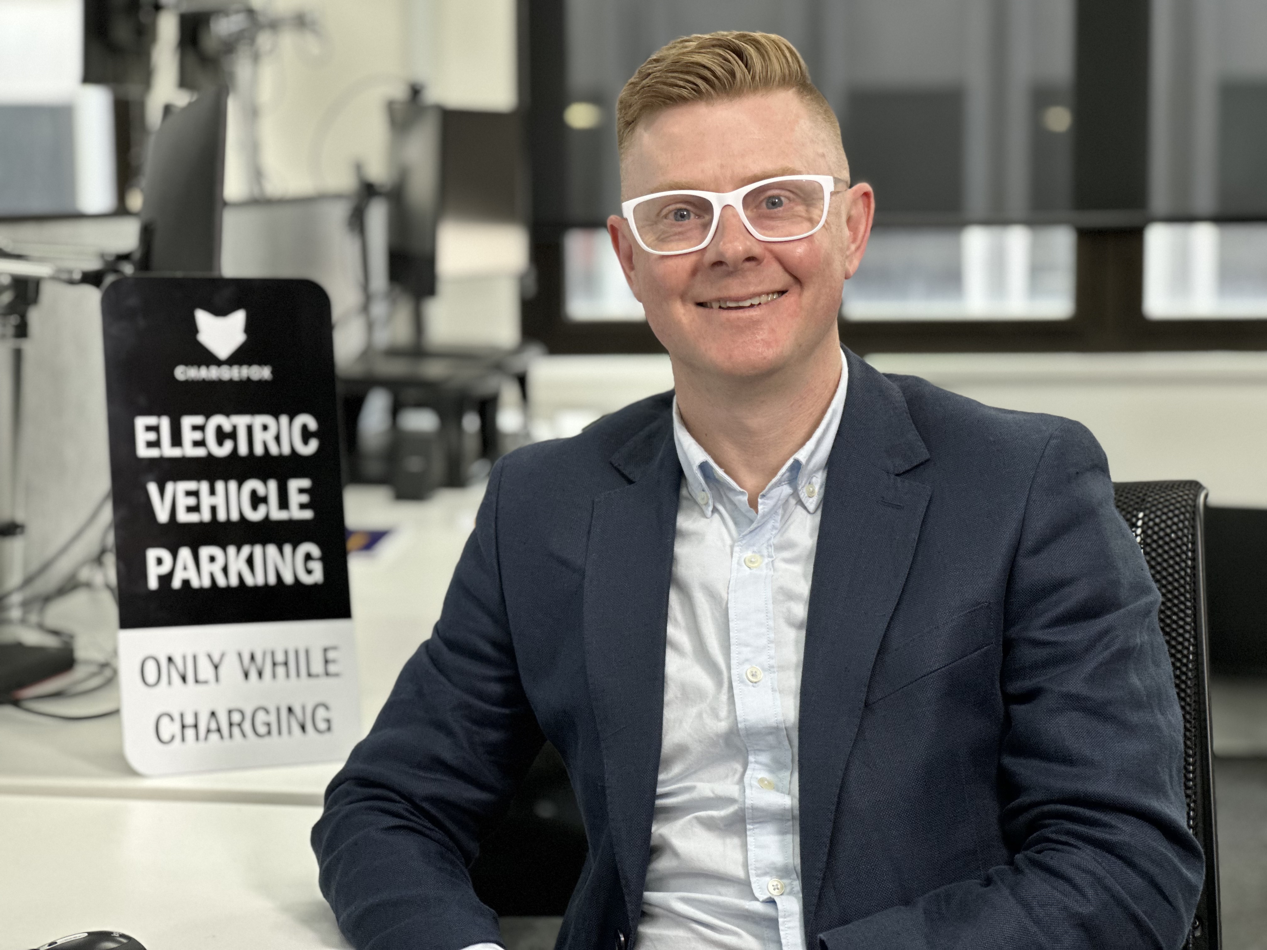 Rob Asselman smiles, sitting in an office.