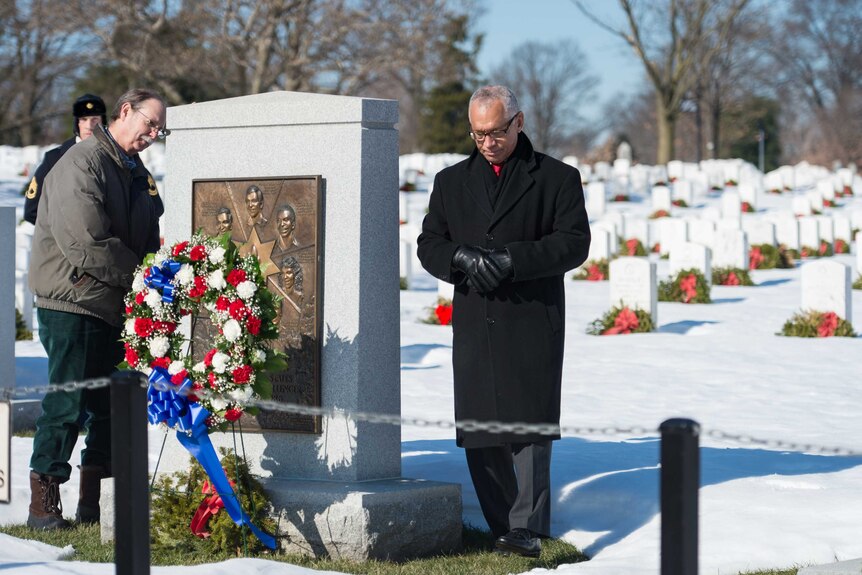 Judith Resnik's brother and a NASA administrator visit the memorial, with graves in the background.