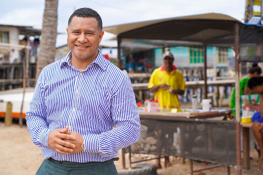 A Papua New Guinean man in a blue and white striped shirt 