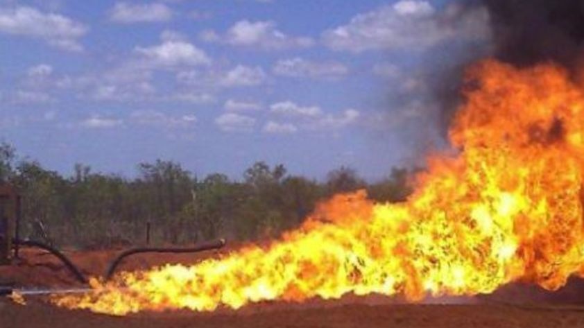 A large flame flares from a gas well.