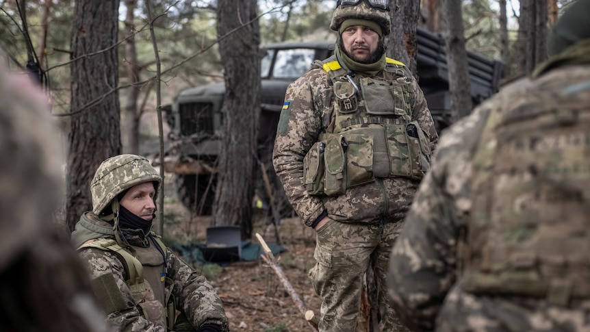 Ukrainian service members rest near their position at a frontline.