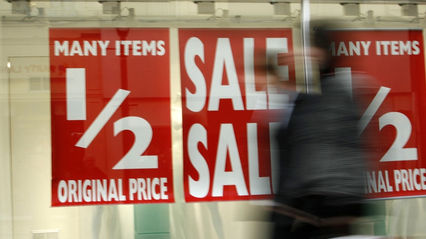 Half-price sale signage hangs in a store window.