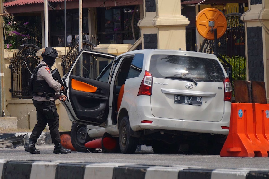 Armed officer inspects minivan