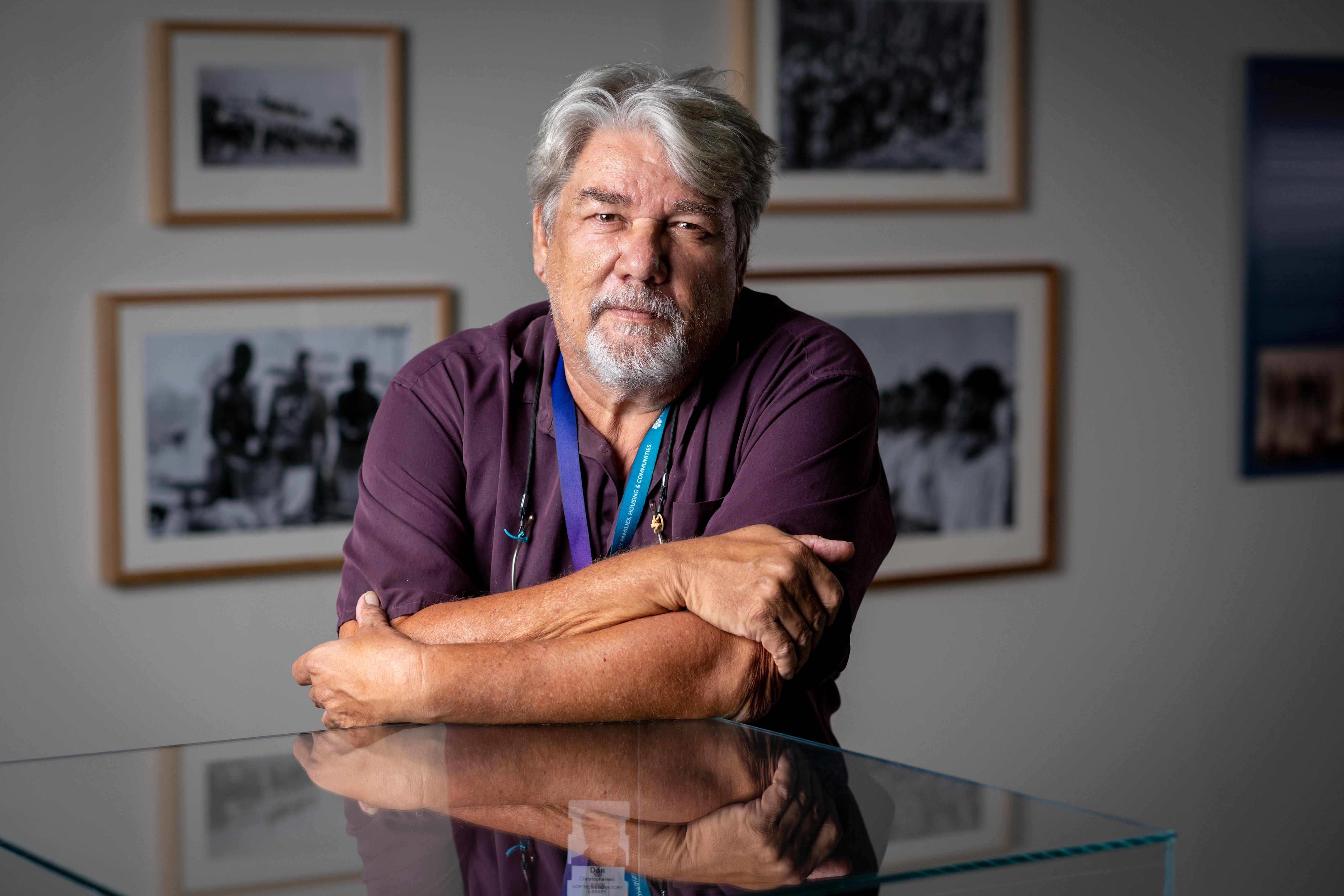 Man leaning on a glass museum cabinet.