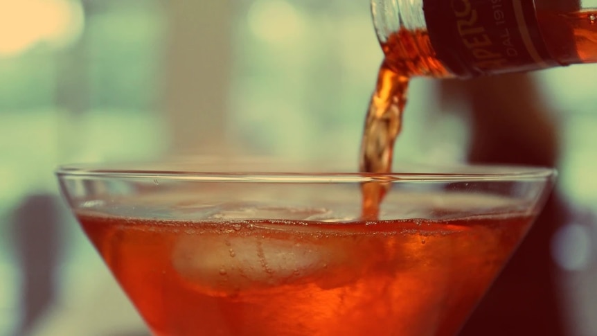 Liquor is poured into a cocktail glass