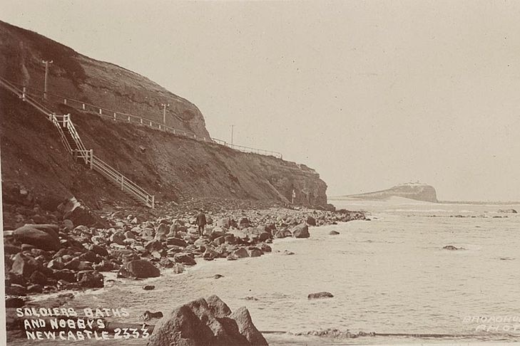 Une vieille photographie sépia d'un rivage rocheux de Newcastle où des marches ont été construites.