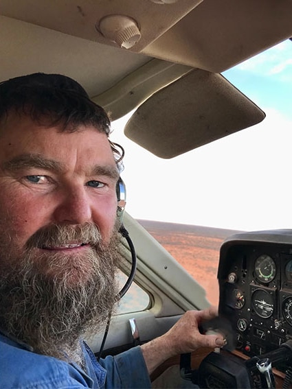 Face of man in plane cockpit with beard and wearing headset 
