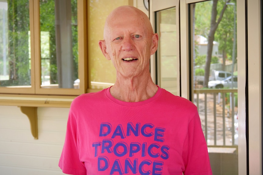 A man in a hot pink short that reads "Dance Tropics Dance"