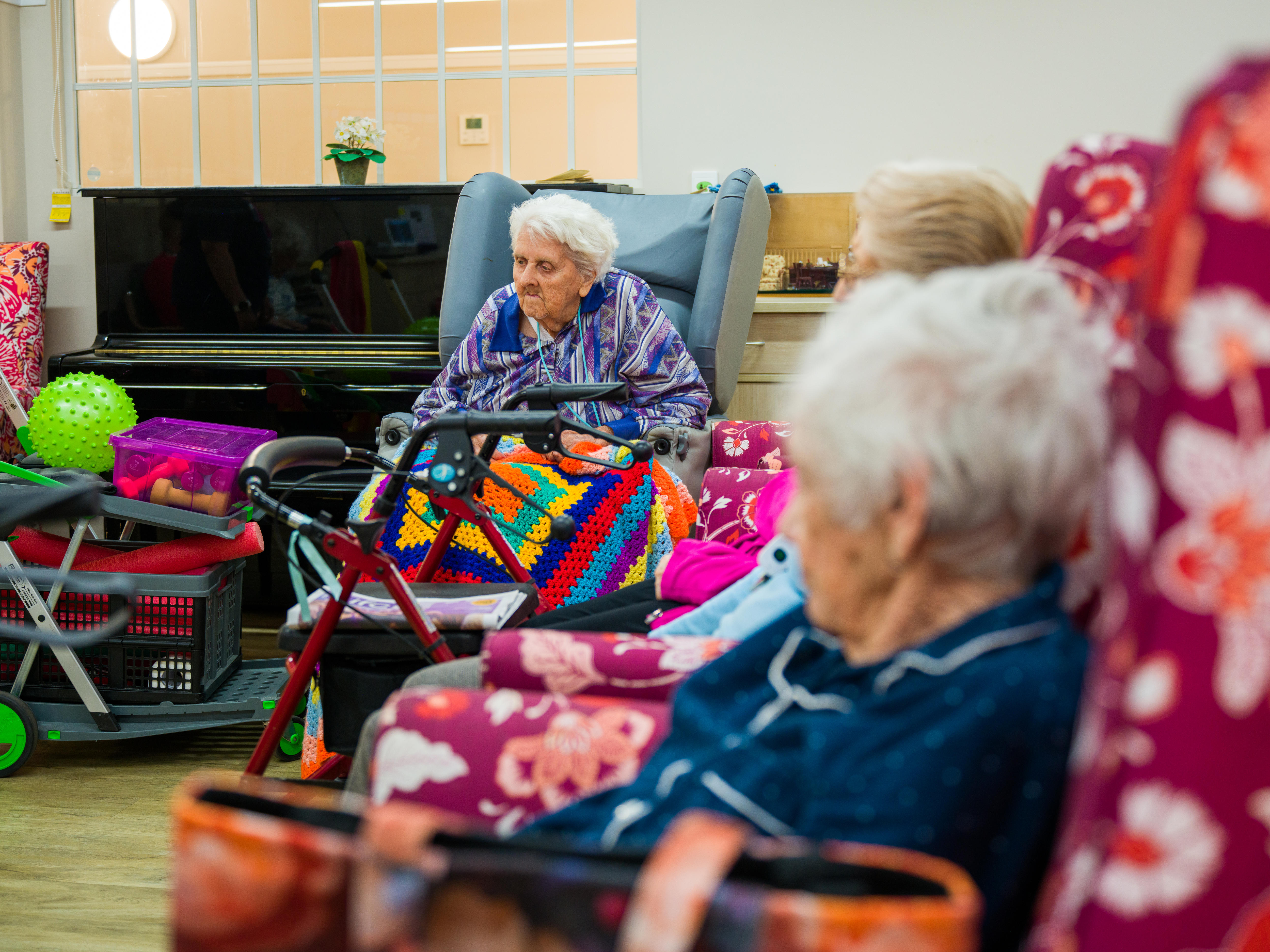 Close up of elderly residents of the centre sitting in chairs.