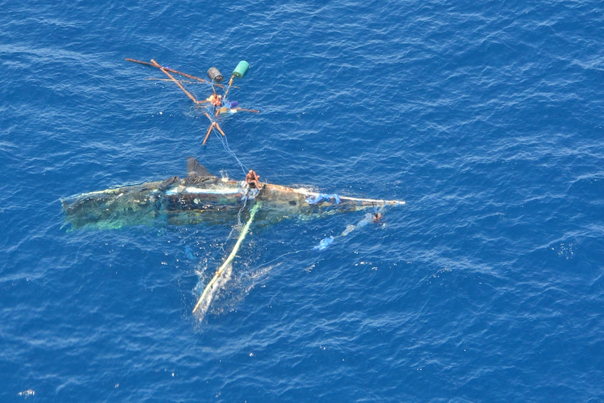 A wrecked boat, capsized and half submerged