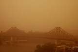 The Story Bridge in Brisbane's CBD is partly obscured by a dust storm as it rolls through the city.