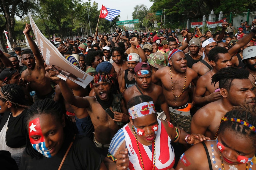 Papuan students fill a street and shout slogans during a rally near the presidential palace in Jakarta.