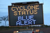 A transportable roadside electronic sign which reads "Cyclone Status Blue Alert".
