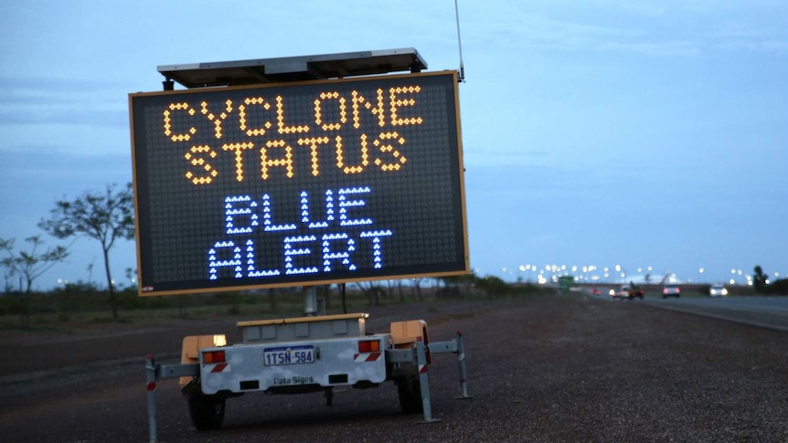 A transportable roadside electronic sign which reads "Cyclone Status Blue Alert".