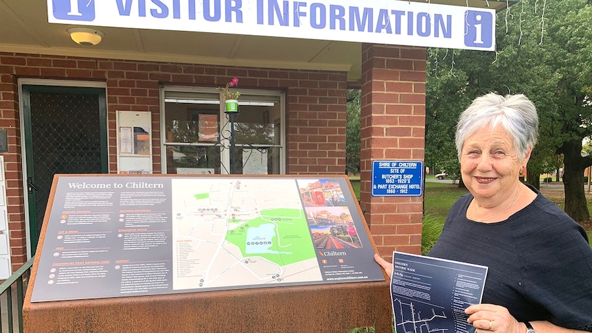 Faye Lappin stands outside Chiltern's Visitor Information Centre holding a historic walk map