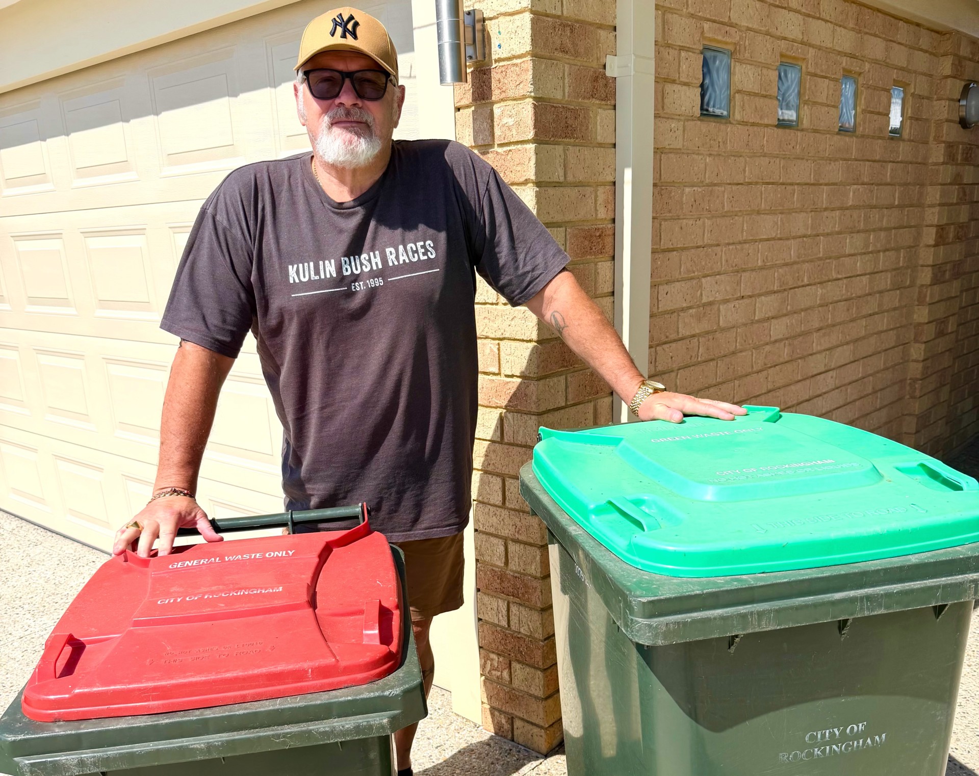 Un hombre está allí con un contenedor rojo y uno verde. 