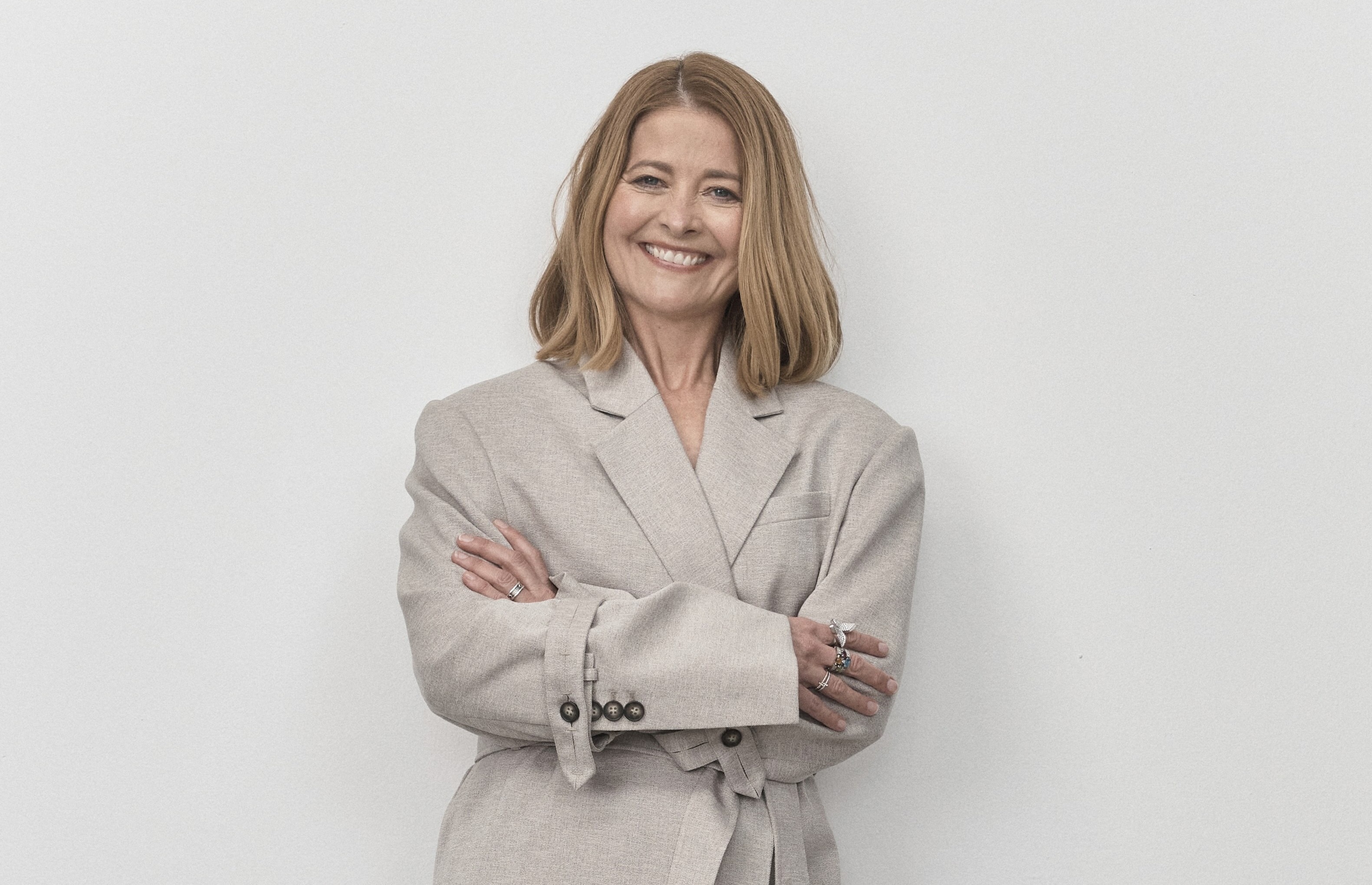 Senhora de terno sorrindo para a câmera