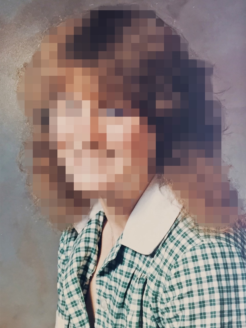 A portrait of a woman in school uniform, with her face pixellated.