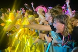 young people crowded on the stage barrier at a music concert