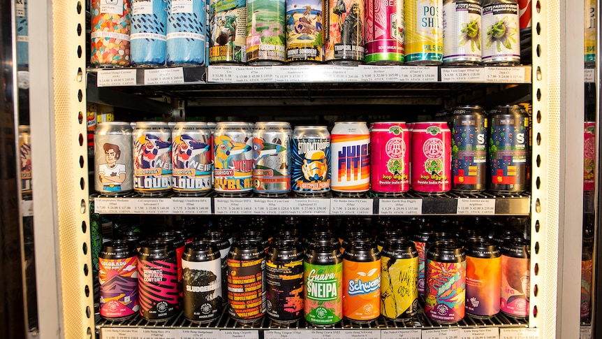 A bottle shop fridge full of brightly coloured craft beer cans