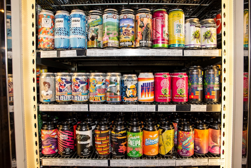 A bottle shop fridge full of brightly coloured craft beer cans