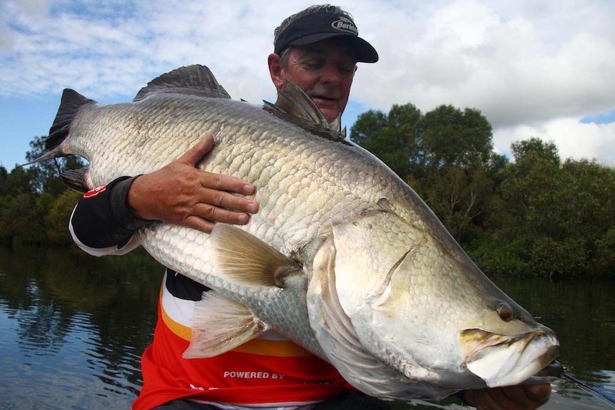 A man holds a very big fish.