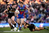 Fletcher Sharpe of the Knights is tackled by Izack Tago of the Panthers 