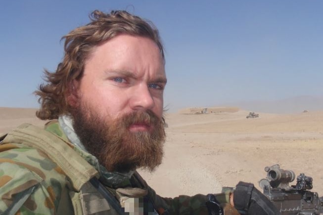 Dan Pronk, with hair flapping in the wind, wearing arm greens and facing camera with stern expression.