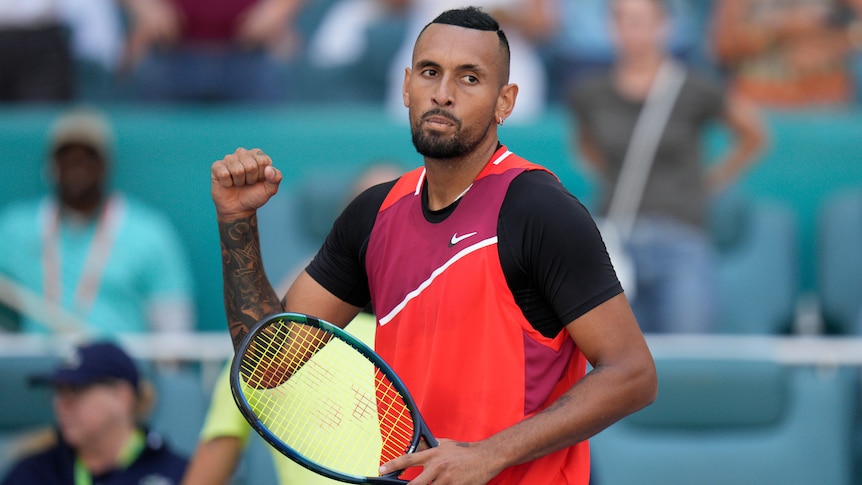 Nick Kyrgios pumps his fist in celebration as he looks toward the stands after winning a match.