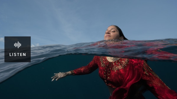 Parvyn swims in a blue ocean, she is wearing a red gown. Has Audio.