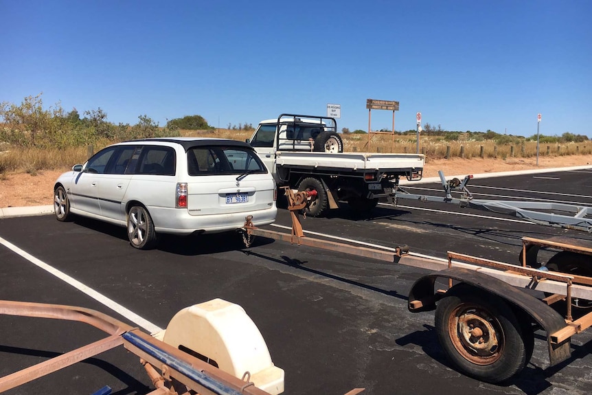 A car and a boat trailer belonging to a missing fisherman parked at a boat ramp.