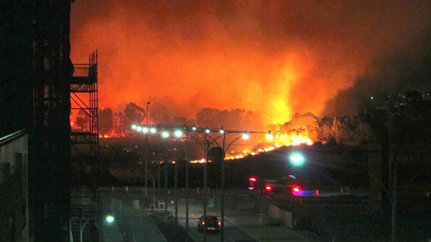 Flames shoot into the air at night at the proposed Dockers site
