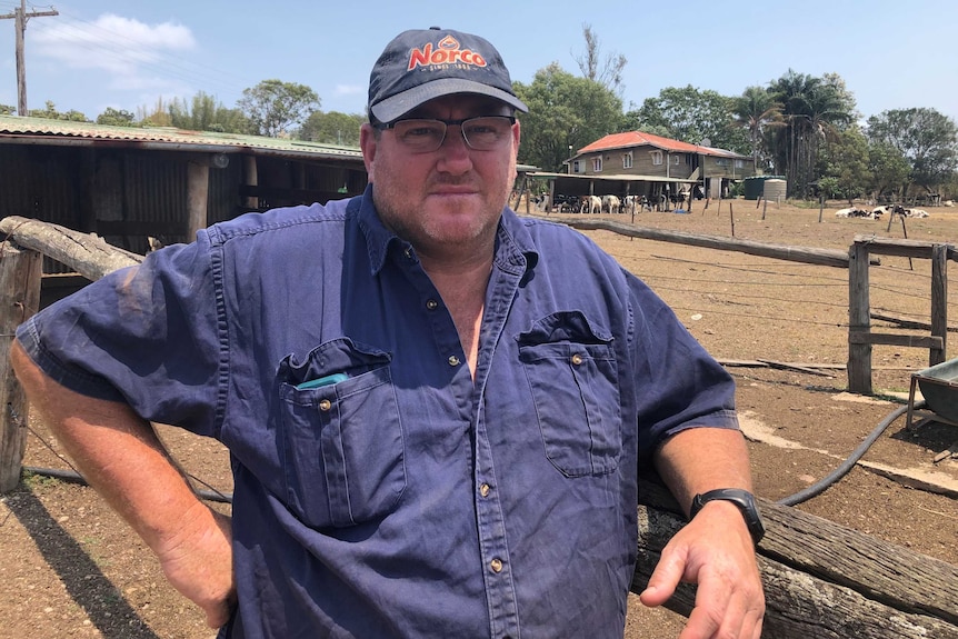 A dairy farmer in a cap on his property