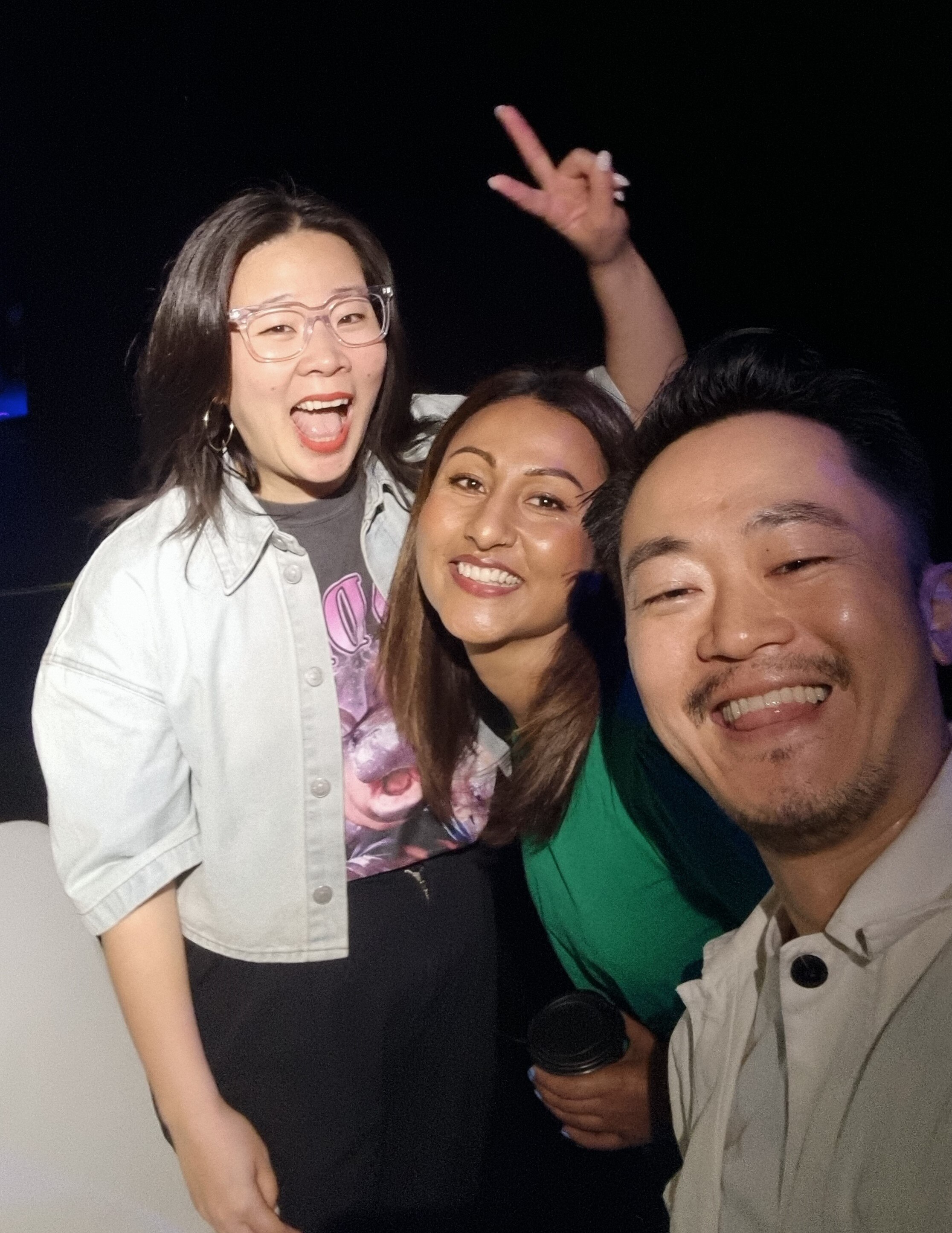 Three people pose for the camera, they're all very happy and excited