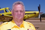 man stands in front of a yellow plane.
