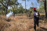 a man lighting a fire in scrub