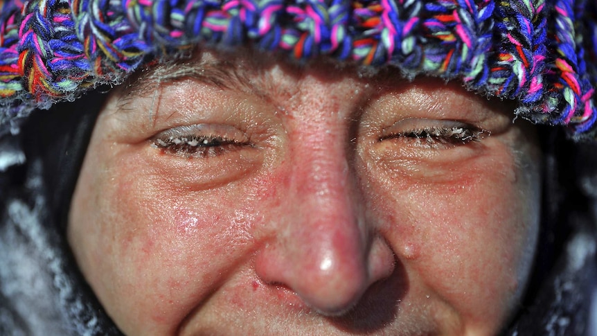 Close up of smiling woman with frozen eyelashes and red face