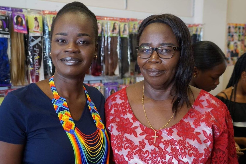 Christine and Jean Kute smile at the camera in their African hair salon.