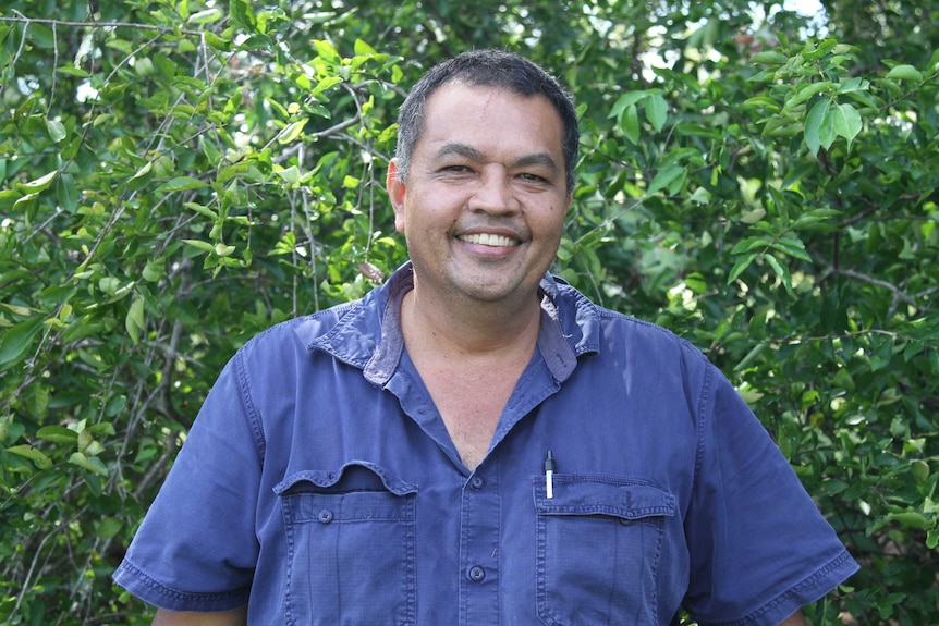Man standing in blue shirt smiling
