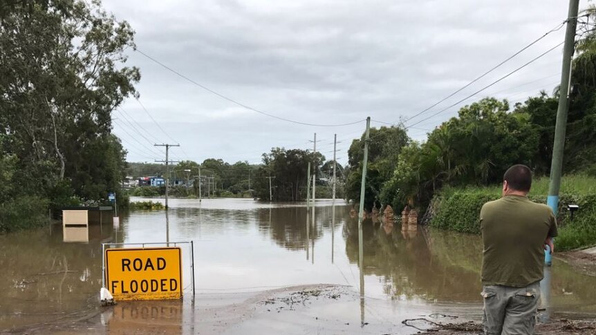 A road flooded sign sits in floodwaters in beenleigh.