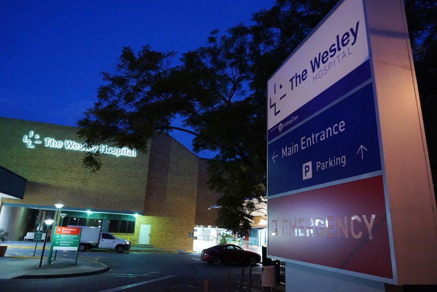 A sign outside the wesley hospital entrance points to the main entrance.