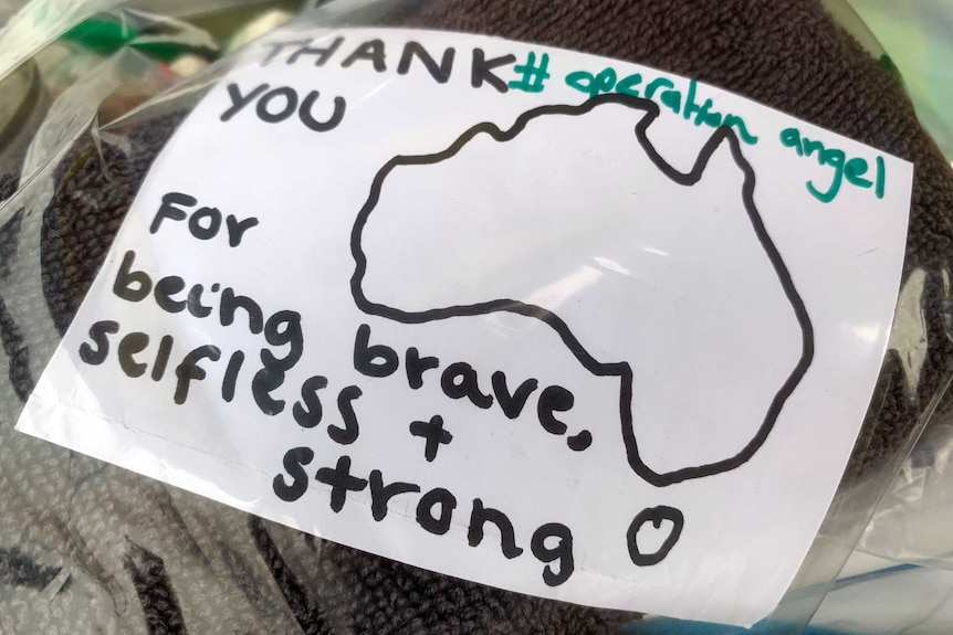 A hand written note from a child which says thank you for being brave, selfless and strong in a plastic bag.