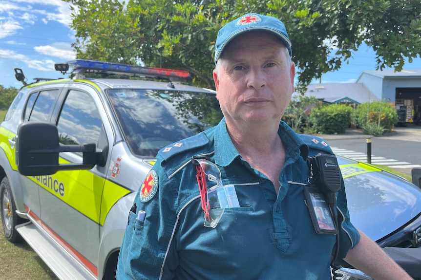 Man wearing green paramedic uniform standing in front of four-wheel-drive ambulance