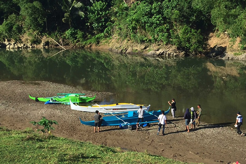 People stand by boats allegedly captured from Philippines terrorist group Abu Sayyaf.