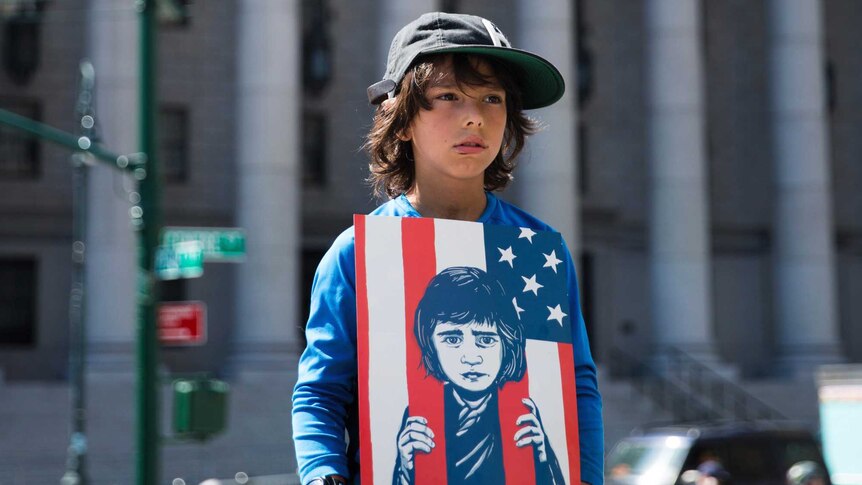 A young child holds a sign during a rally.