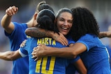 Four Brazilian players embrace as they celebrate a goal in a friendly against Japan.