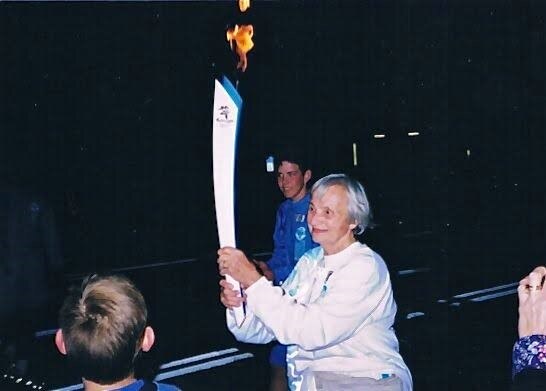 A woman holding Olympic torch.