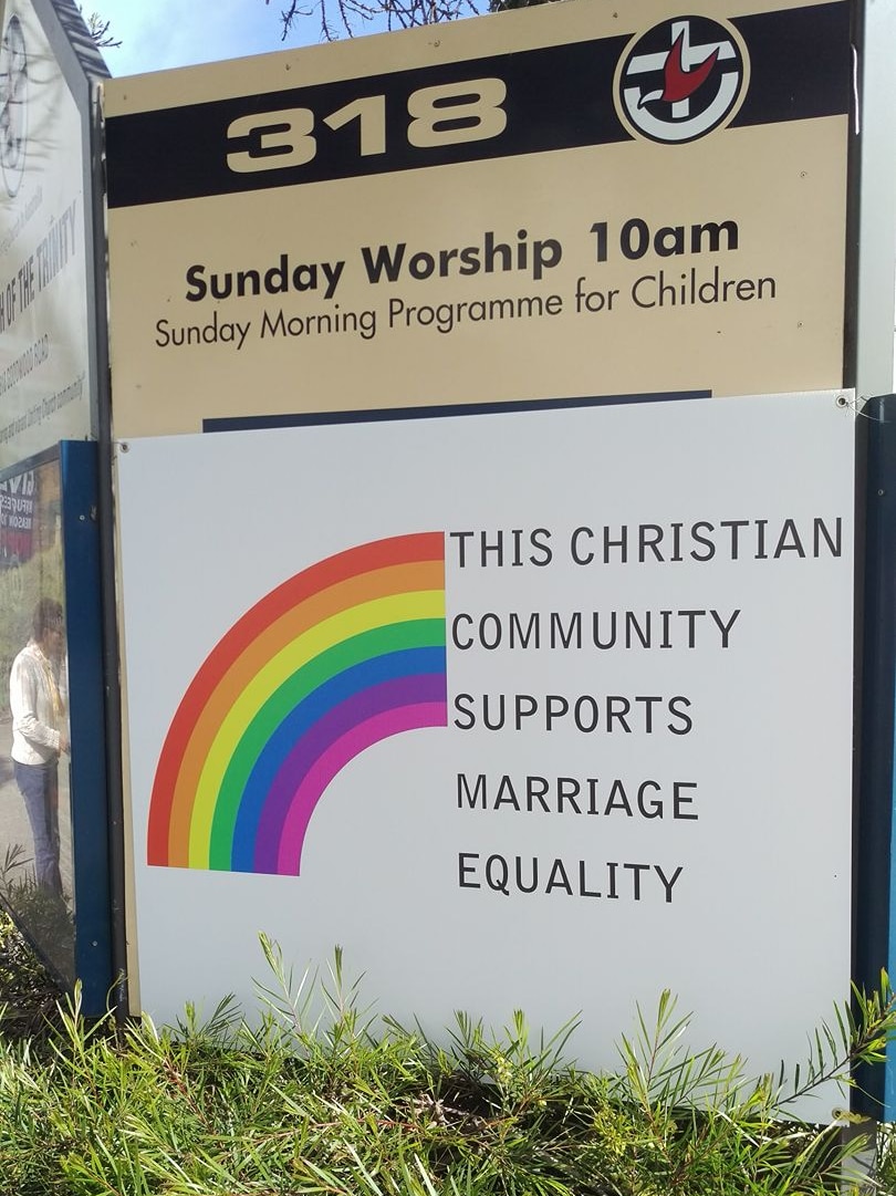 A church sign with a rainbow and words saying it supports marriage equality