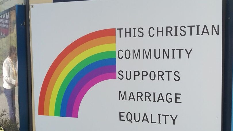 A church sign with a rainbow and words saying it supports marriage equality