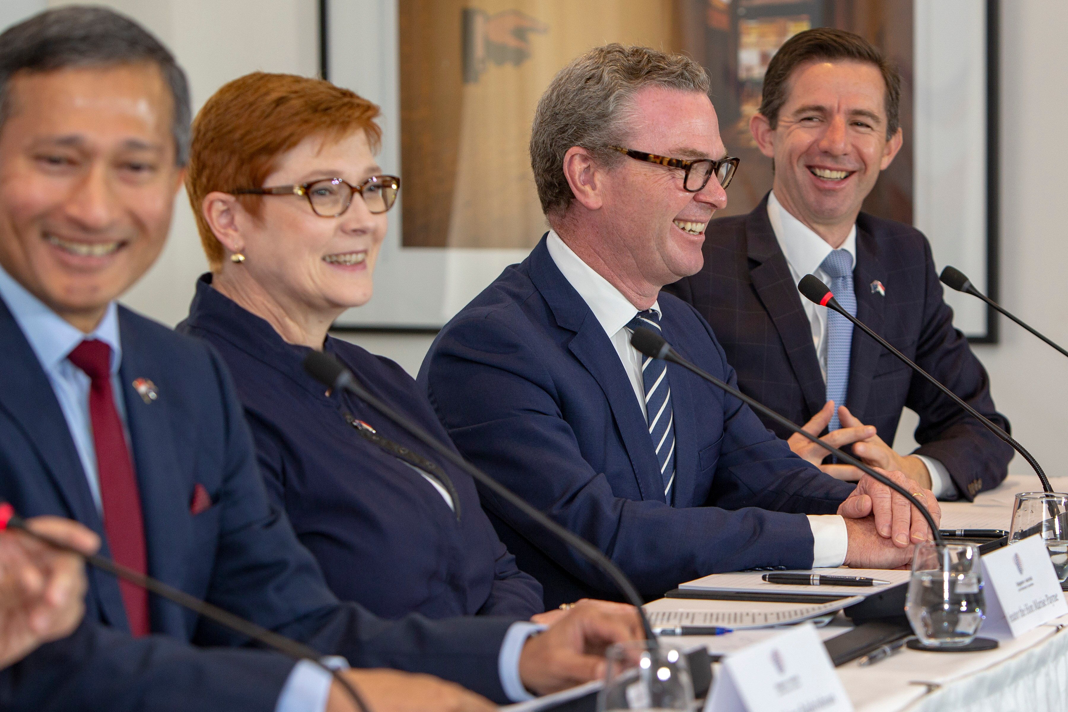 Payne, Pyne abd Birmingham sit in a row at a desk, all smiling.